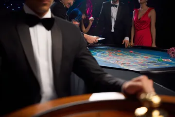 JILIHH Live Casino — Join thrilling real-dealer tables A professional dealer in a tuxedo greeting players at the roulette table, symbolizing the authentic live casino feel at JILIHH.