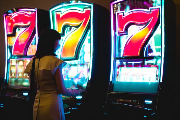 JILIHH Games — Explore our rich library of casino classics A woman smiling while playing online games on her laptop, surrounded by neon casino elements, showcasing JILIHH’s diverse game collection.